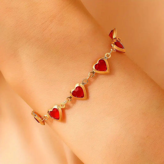 Pulsera de corazones dorada con piedras rojas, vista 2