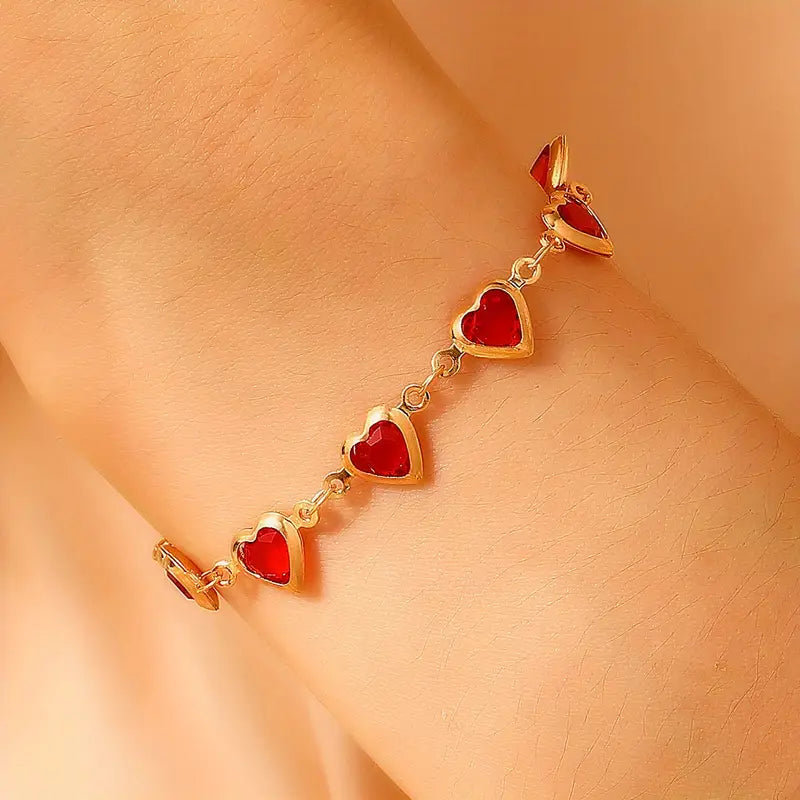 Pulsera de corazones dorada con piedras rojas, vista 2