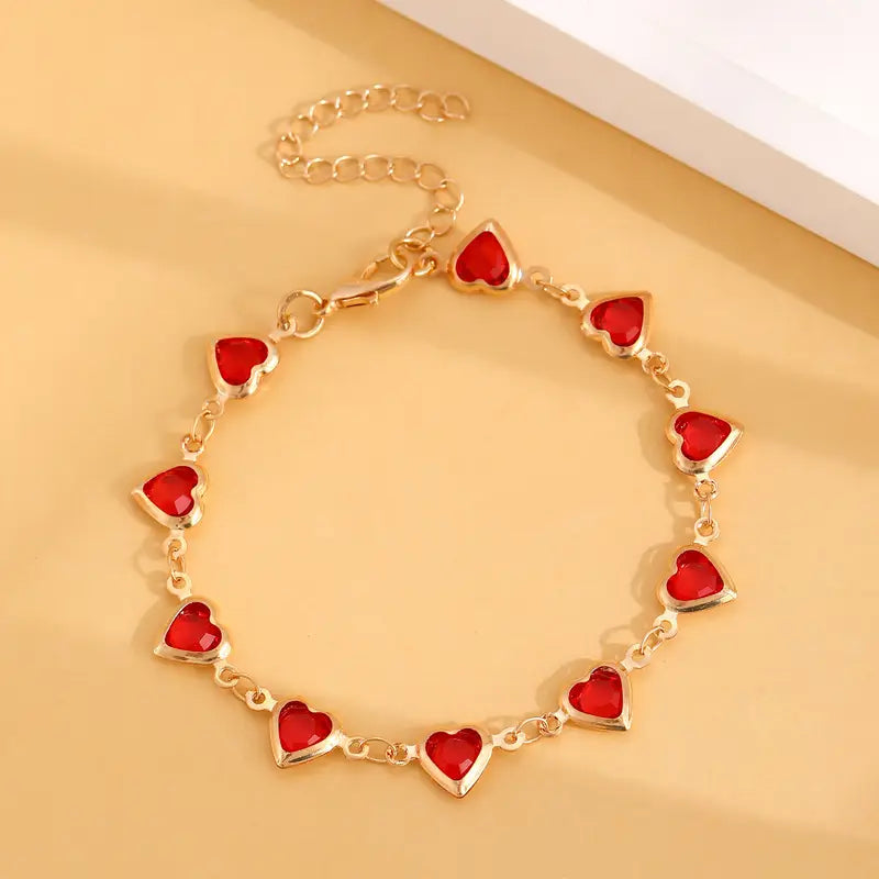 Pulsera de corazones dorada con piedras rojas, vista 3