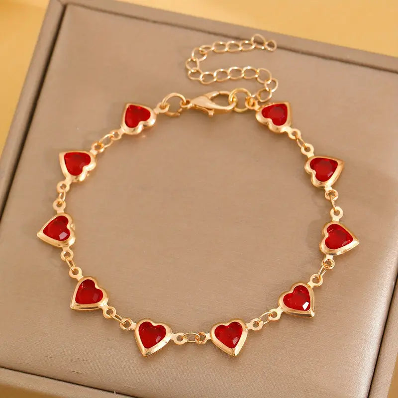 Pulsera de corazones dorada con piedras rojas