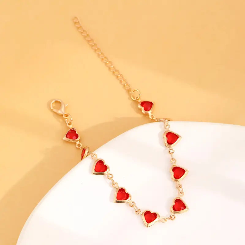 Pulsera de corazones dorada con piedras rojas, vista 4