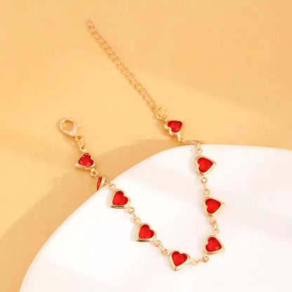 Pulsera de corazones dorada con piedras rojas, vista 4