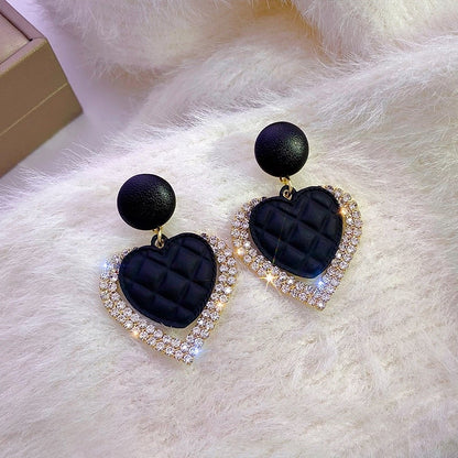 Pendientes de corazón negro dorados, vista 2